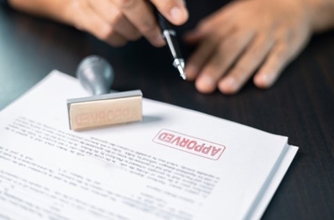 Application on a desk with an approved stamp on it.