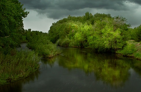 Poudre River winding through natural area on a stormy summer afternoon.