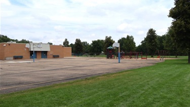 Multi-use sport courts with basketball hoops near a school
