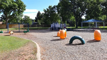 A playground filled with woodchips in a park