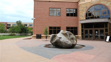 A rock sculpture in front of a building
