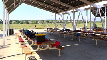Picnic tables underneath a covered shelter at a park