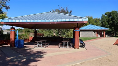 Two covered pavilions next to a park playground