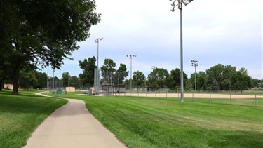 A paved trail running along a baseball diamond