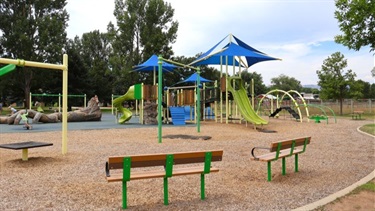 A playground with play structures, slides and benches