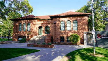 A large brown brick building next to a park