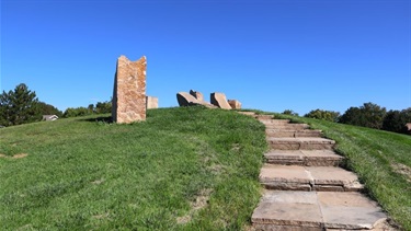 Stone steps leading up a hill to stone sculptures