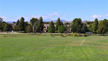 View from a park overlook featuring views of the mountains and a soccer field