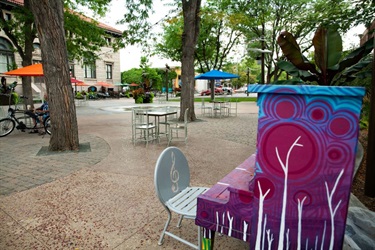 A colorful piano in a downtown plaza