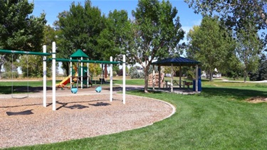 A park playground with swings, slides and a shelter