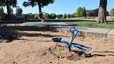 A sand scooper in a sandbox at a park
