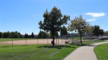 A paved path next to ballfields
