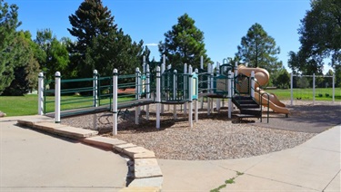 A park playground with climbing structures and a slide