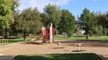A park playground with a small slide and play structures