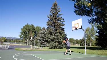 A man bounces a ball on a basketball court
