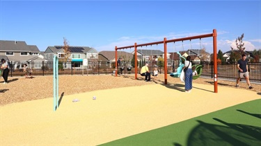 People playing on a swing set at a park playground
