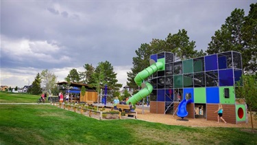A playground with a large multi-colored play structure and slide
