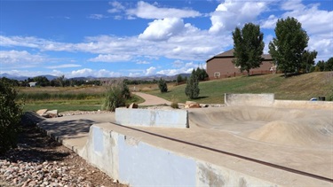 A skate park next to a neighborhood with views of the foothills