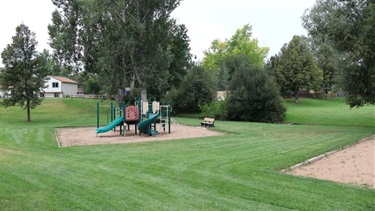 A park featuring a playground a lots of green space