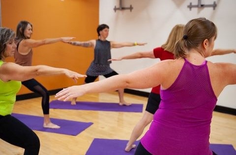 A group of women do yoga in a fitness room
