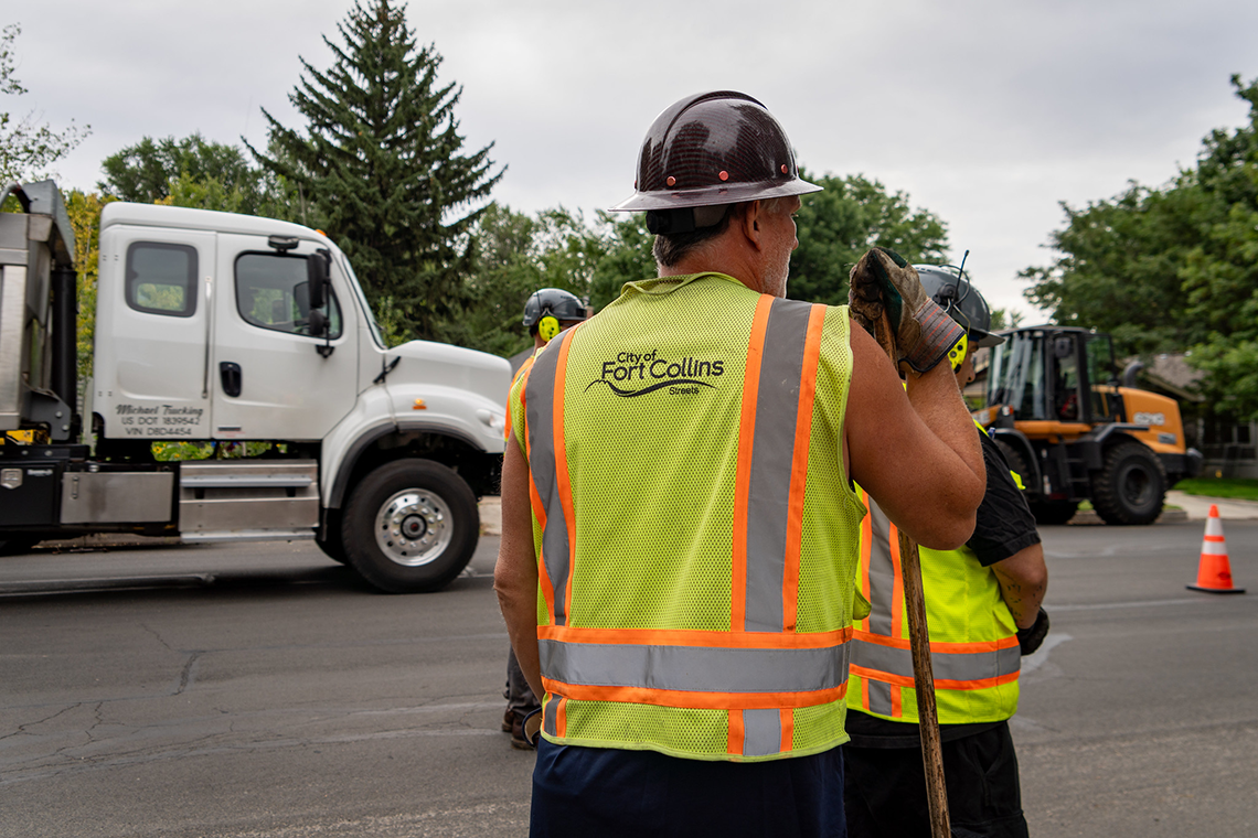 two construction workers standing on a street