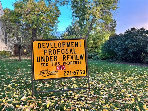 A Development Review sign in front of a house in Fort Collins
