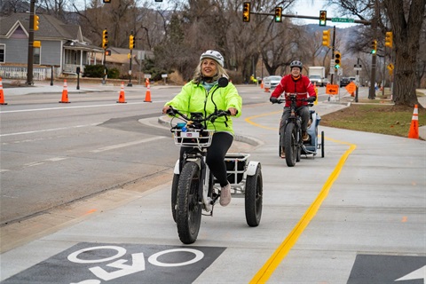 Two adults commuting on bicycles on a bike path in Fort Collins