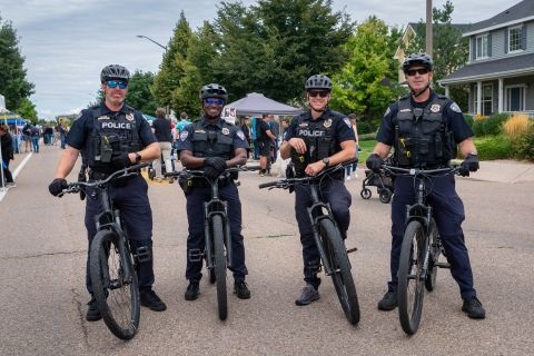 Four police officers standing with bicycles