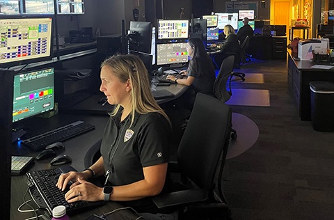 A person works in front of a computer in the police dispatch center