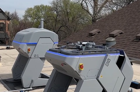 Two launch and landing pad units, and a drone preparing for liftoff, on top of the Police Services headquarters