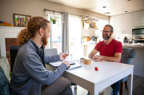 A homeowner smiles while speaking to an Epic Homes representative following a home assessment.