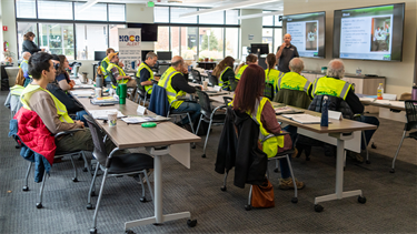 classroom of people in reflective vests for training