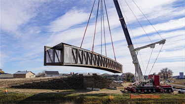 large bridge held midair by crane