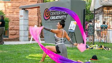 performer twirls large ribbons outside
