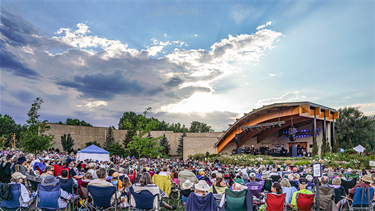 large crowd in chairs at outdoor pavilion concert