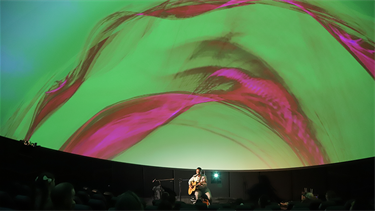 bright green and purples projected onto the IMAX Dome