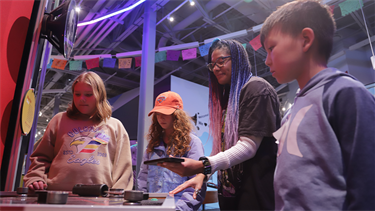 adult and children play with interactive exhibit