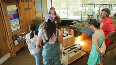person educates small group of listeners indoors