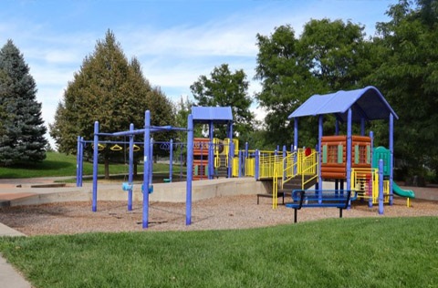 A brightly colored playground surrounded by trees